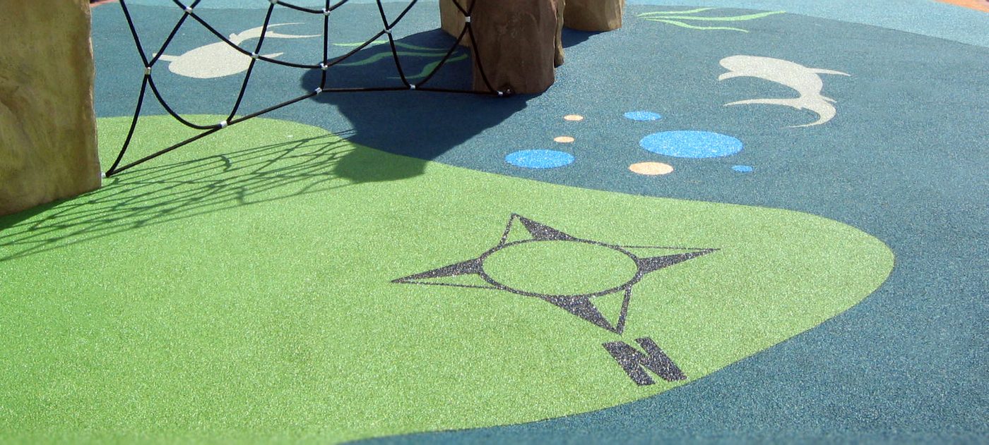 Green and blue wet-pour rubber safety surfacing in a play area